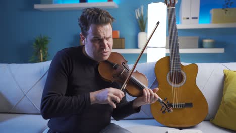 angry and sullen musician man playing violin at home.