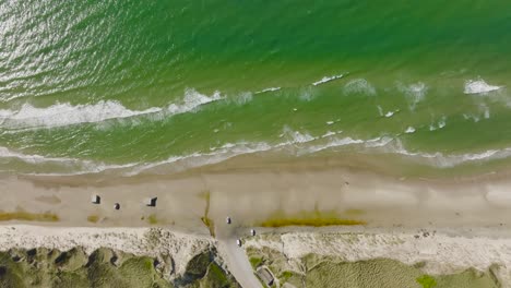 aerial view, waves of the north sea wash the sand of the wild beach