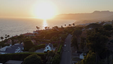 flyover exclusive malibu street toward misty golden ocean sunset