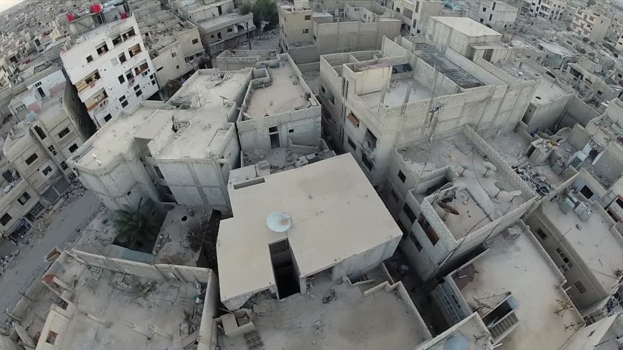 Ripresa aerea di edifici e strade in rovina in Siria.