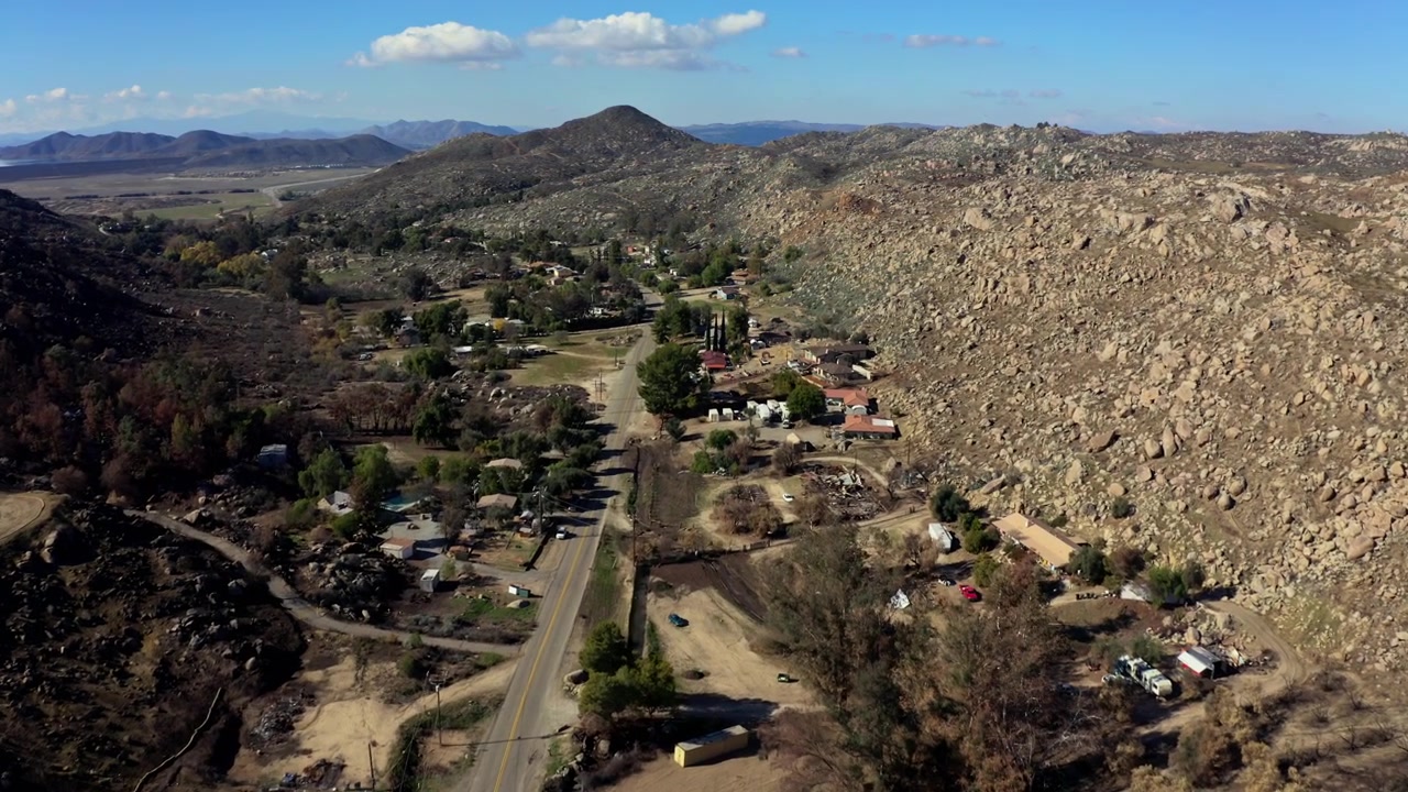Drone view of wildfire damaged location in San Bernardino, California with the mountains in the background