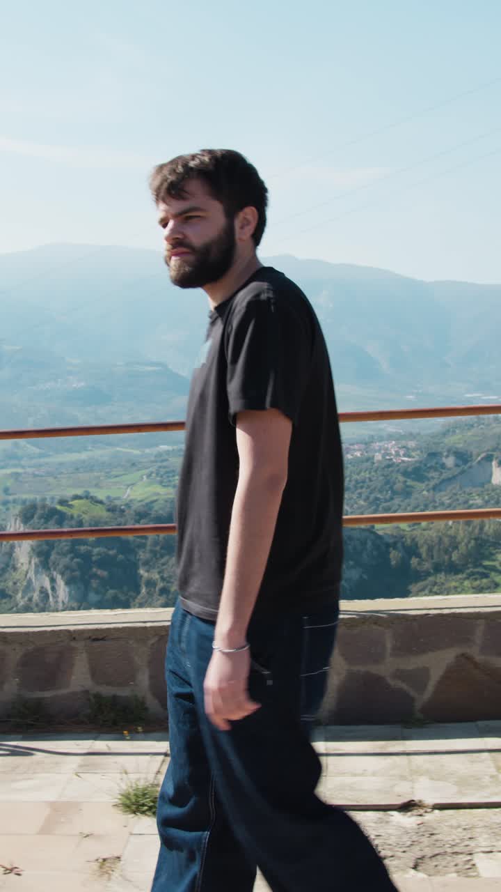 Giovane uomo che cammina nel parco con vista sul paesaggio della Calabria
