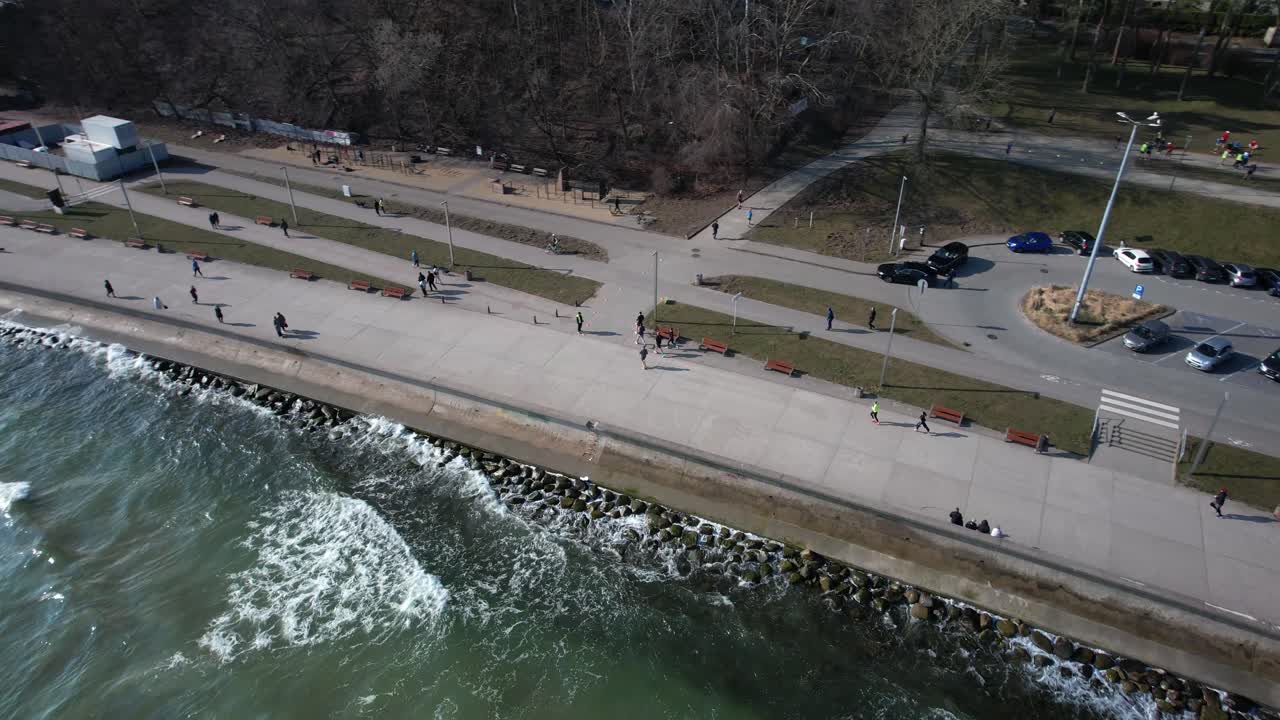 People running along Gdynia promenade. Joggers on scenic coastal path, in Poland