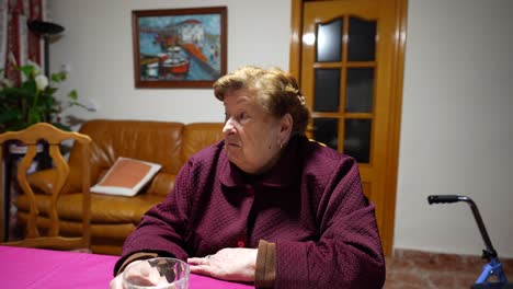 adorable old lady talking and making grimaces of strangeness in house living room