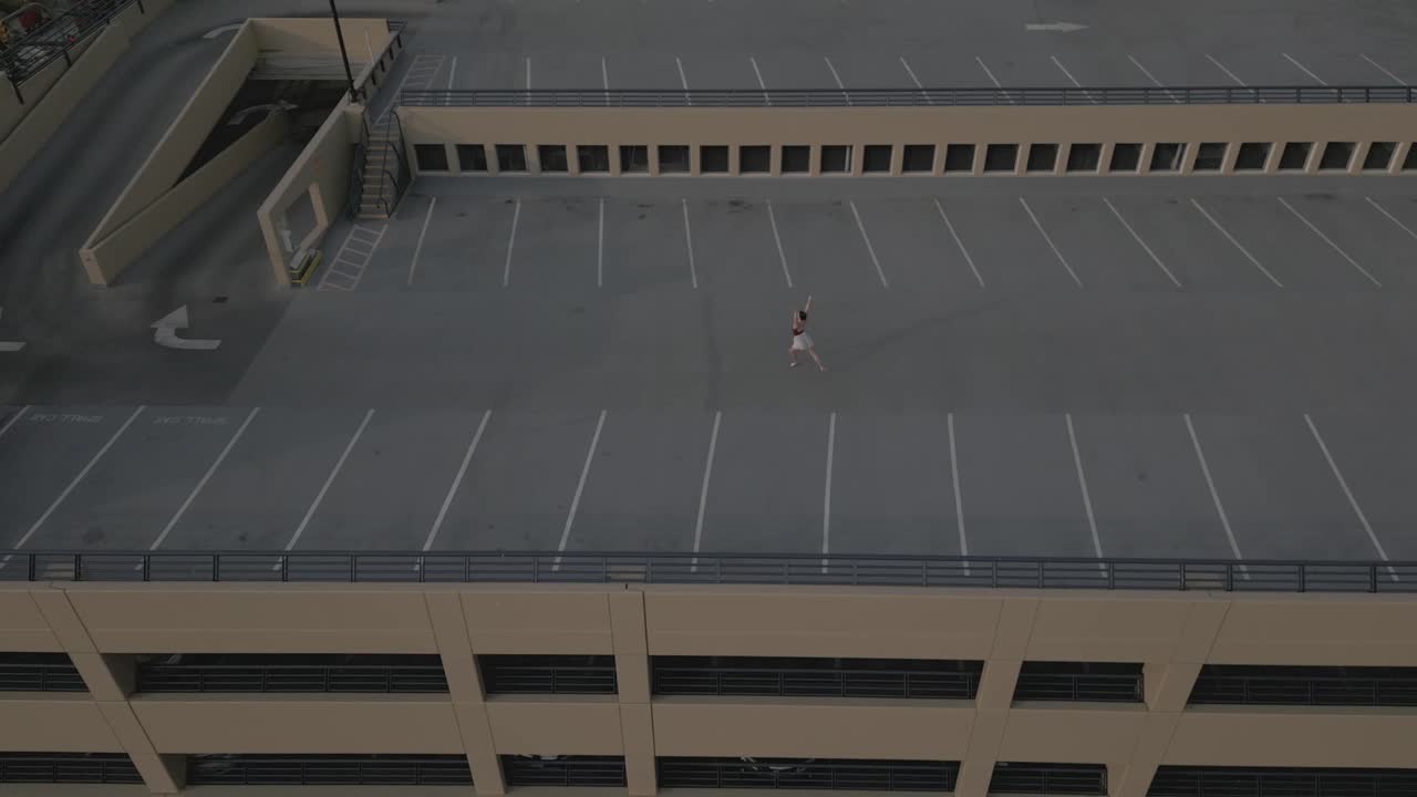 Ballet dancer alone on a parkade roof in a city