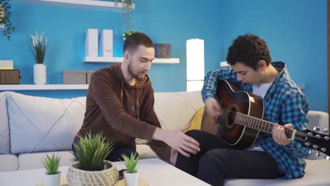 the cynical elder brother is teaching his younger brother to play the guitar.