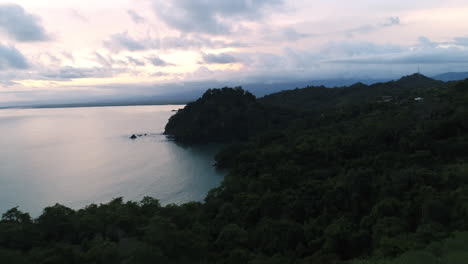sunrise aerial coming over jungle treetops with pacific coast in distance, 4k