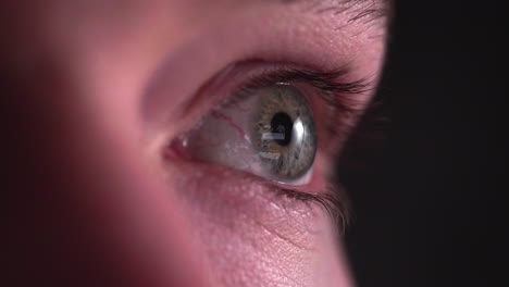 overworked eye looking and browsing smartphone, screen reflected on eye - close up, macro shot