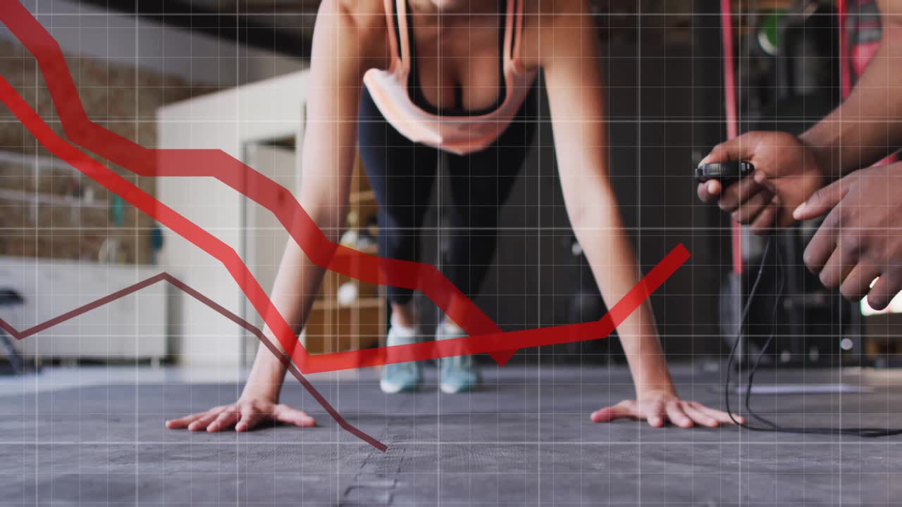 Entrenador iniciando el cronómetro mientras el/la entrenado/a realiza flexiones en una colchoneta de goma con líneas métricas rojas ascendiendo.
