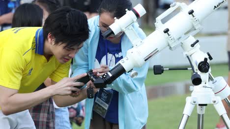 students learning to use a telescope outdoors