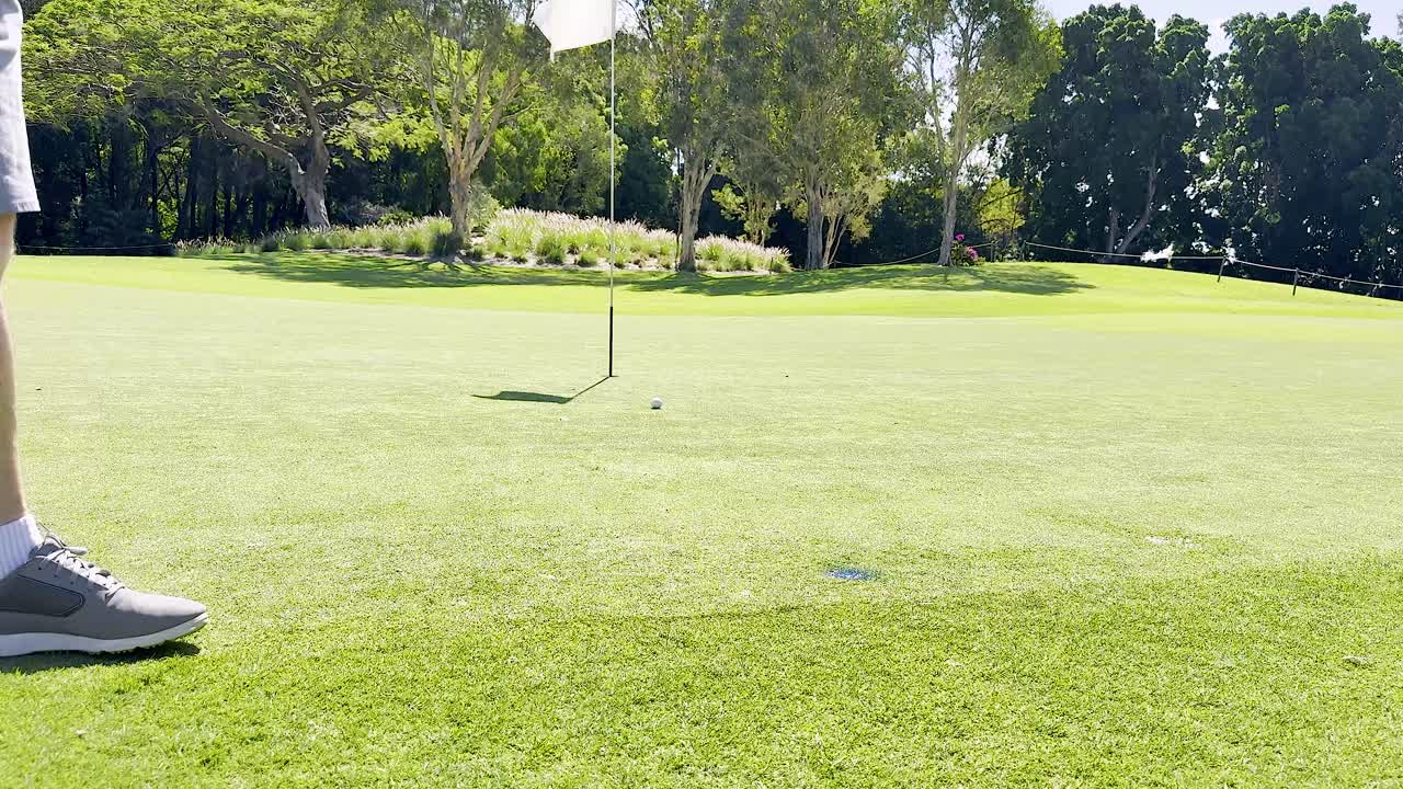 골퍼가 구을 향해 공을 던집니다.