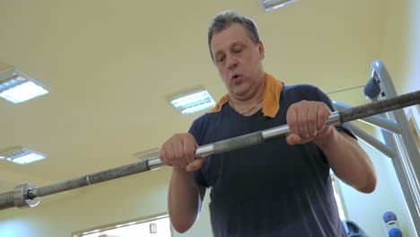 man exercising with crossbar in the gym