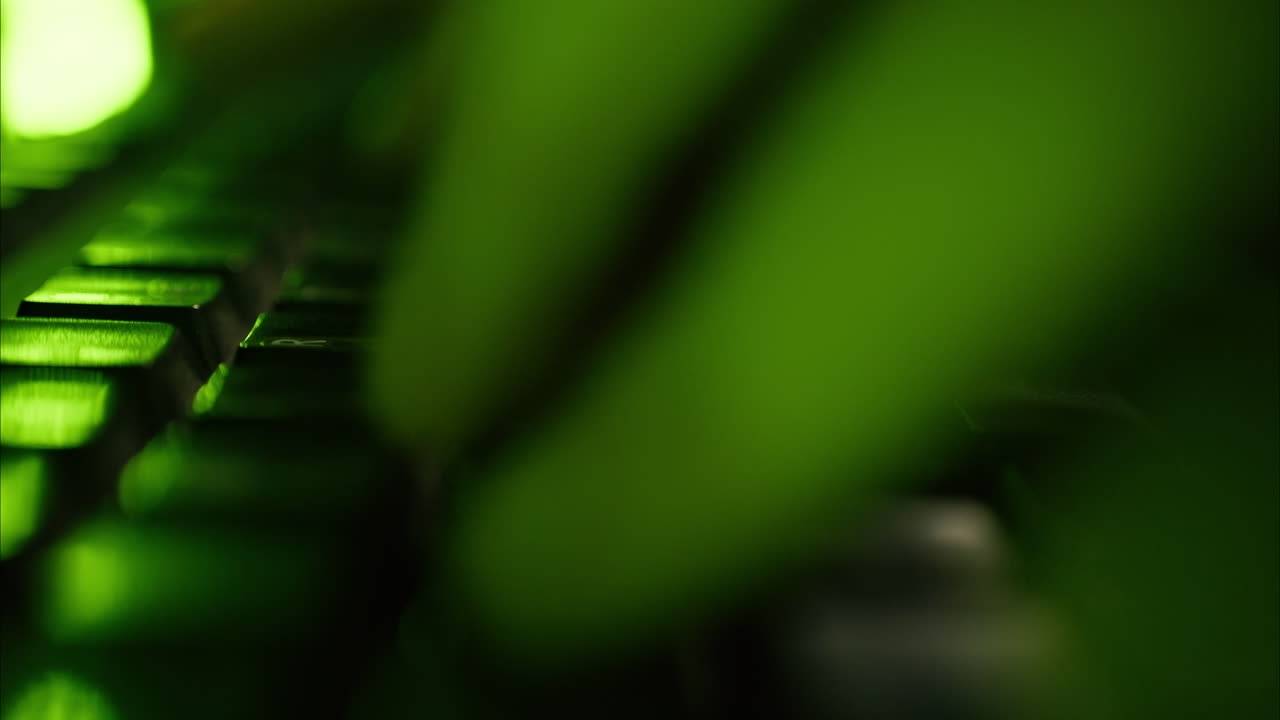 Close up of a man programming in a server room with green lights