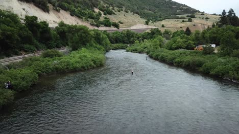 disparo de drones acercándose a un hombre pescando con mosca en el río provo en las montañas de utah-2