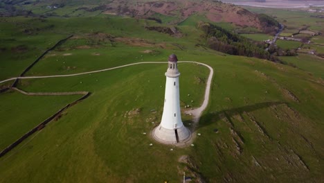 Luftaufnahme-Des-Sir-John-Barrow-Monuments-Mit-Neigung-Nach-Unten,-Abschließend-Eine-Direkte-Draufsicht-Auf-Das-Von-Grün-Umgebene-Wahrzeichen