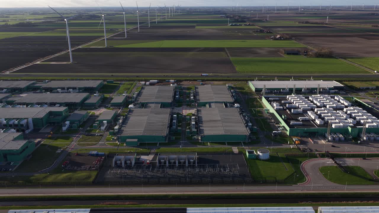 Aerial drone footage of large-scale computing and telecommunications infrastructure, showing an advanced datacenter complex with server systems, cloud connectivity, and digital technology in Hollands