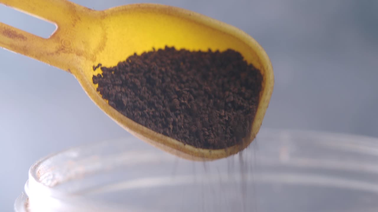 Pouring Coffee Grounds into a Container