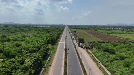 aerial view of a highway running through lush green fields in amaravathi, vijayawada, india.