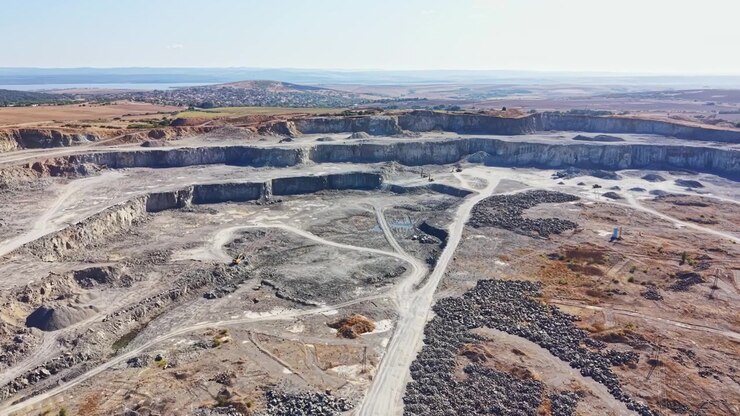 Granite quarry showing active stone extraction and heavy machinery on site in a rural area