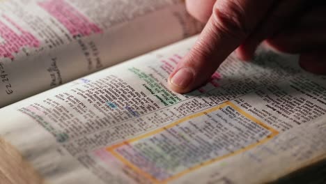man reading book scrolling with index finger