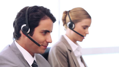 trabajadores del centro de llamadas hablando en auriculares.