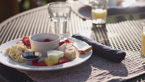 cacerola sobre un colorido plato de desayuno, mesa exterior a la luz del sol