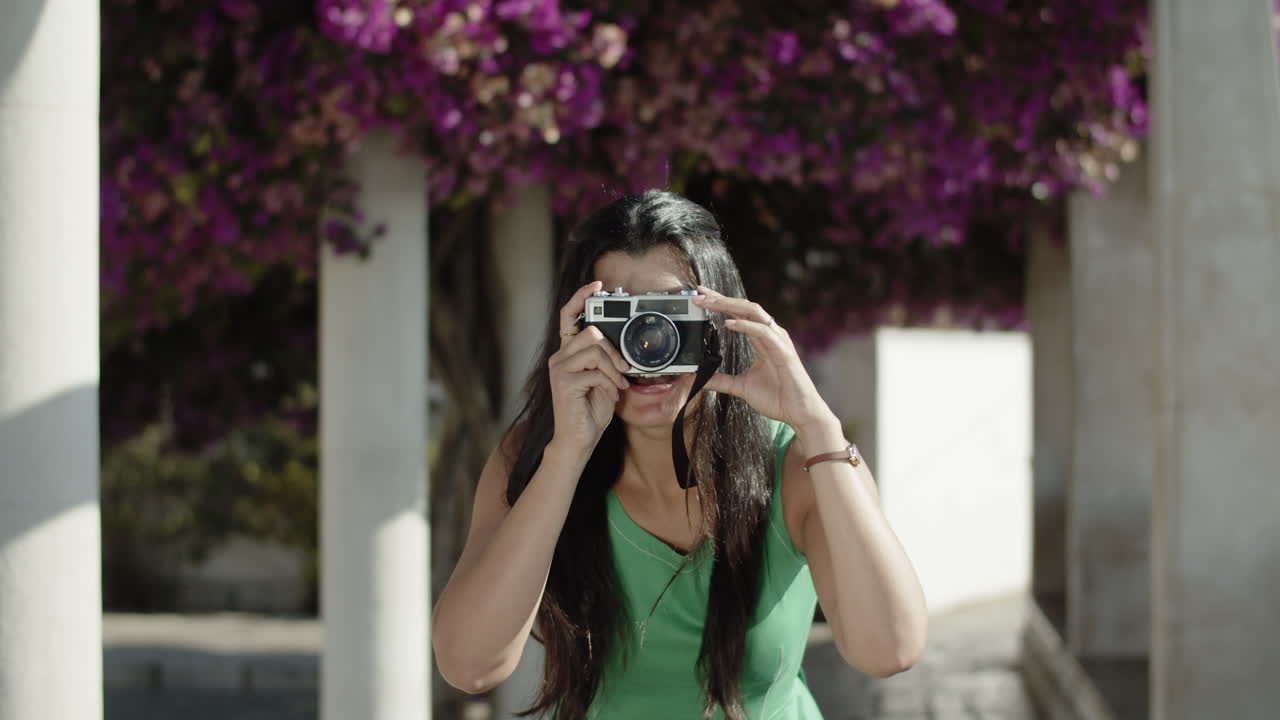 Vista frontale di una giovane donna ispanica che scatta una foto con la macchina fotografica