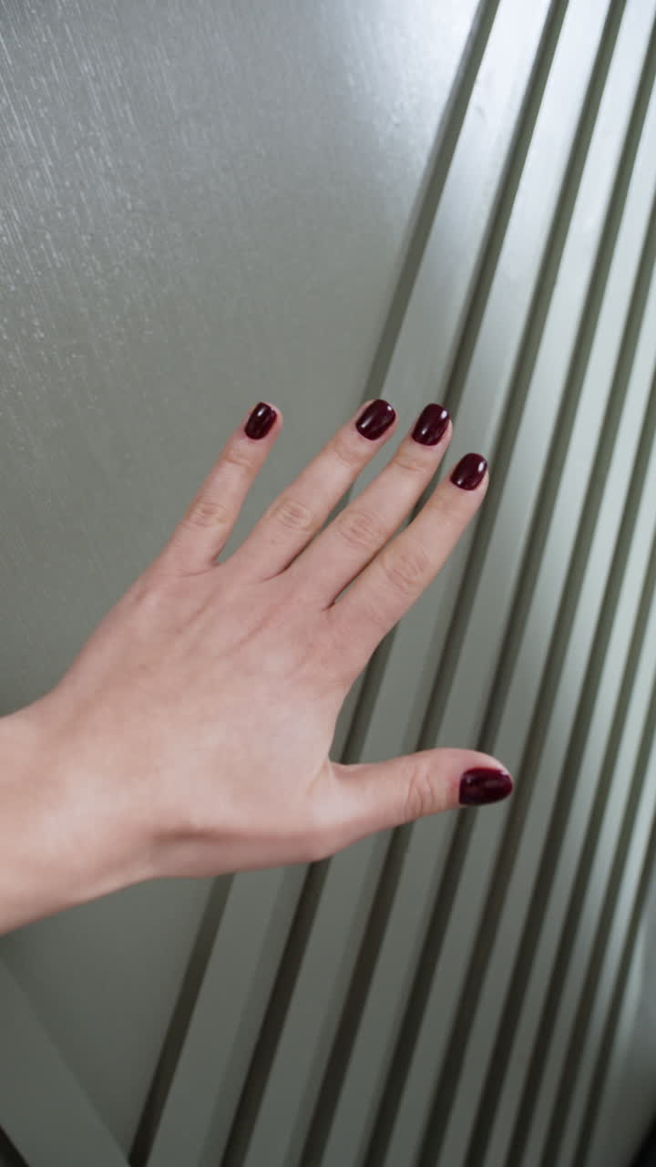 Woman's hand with maroon nails