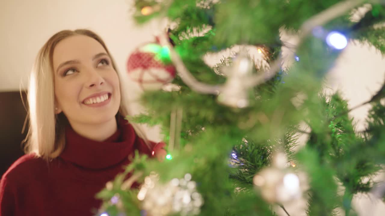 mujer feliz decorando el árbol de navidad