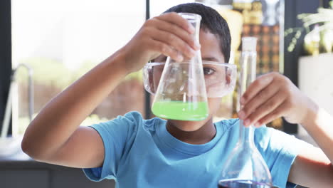 in a school setting, in a classroom, an african american student conducts a science experiment