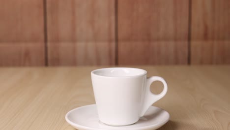 a coffee cup sits on a wooden table