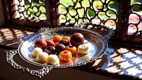 sweet treats on an ornamental tray by a window