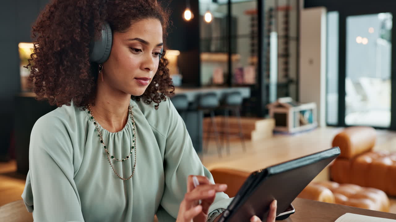 Woman with Headphones Using Tablet in Modern Office