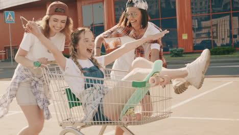 amigos divirtiéndose con un carrito de compras