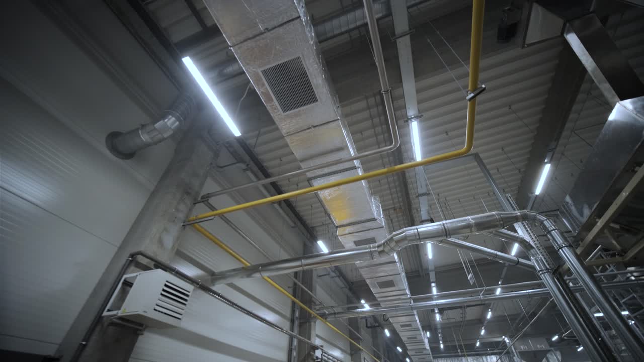 limpieza de conductos de aire acondicionado, tuberías de ventilación en material aislante de plata colgando del techo dentro de un edificio nuevo.