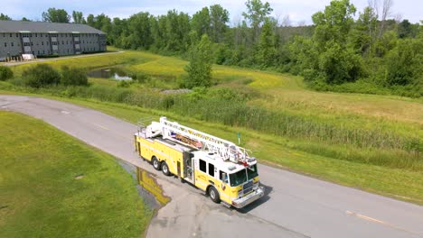 ladder firetruck backing up onto road during fire drill training – aerial view