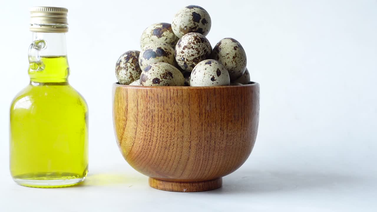 huevos de codorniz en un cuenco de madera con aceite de oliva