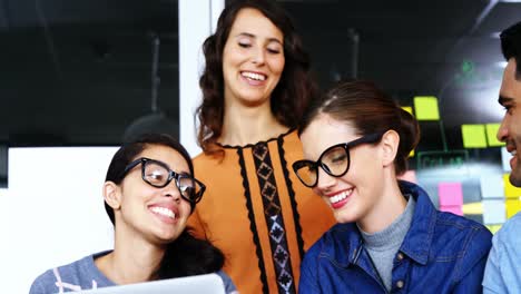 ejecutivos sonrientes discutiendo sobre la computadora portátil durante la reunión