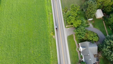 Amischer-Buggy-Auf-Stark-Befahrener-Landstraße,-Vorbeifahrende-Autos,-Drohnenaufnahme-Aus-Der-Luft