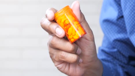 persona que sostiene un frasco de pastillas