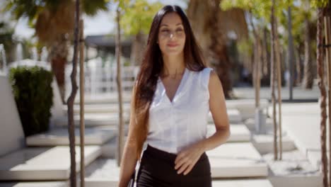 young businesswoman walking through a park