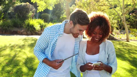 Happy-couple-using-digital-tablet-and-mobile-phone