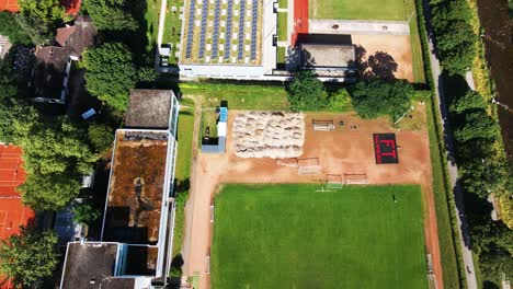 "Get-a-bird's-eye-view-of-Freiburg-im-Breisgau's-vibrant-cityscape-and-lush-parks,-with-drone-footage-showcasing-soccer-fields-where-locals-gather-for-spirited-matches-under-the-sun