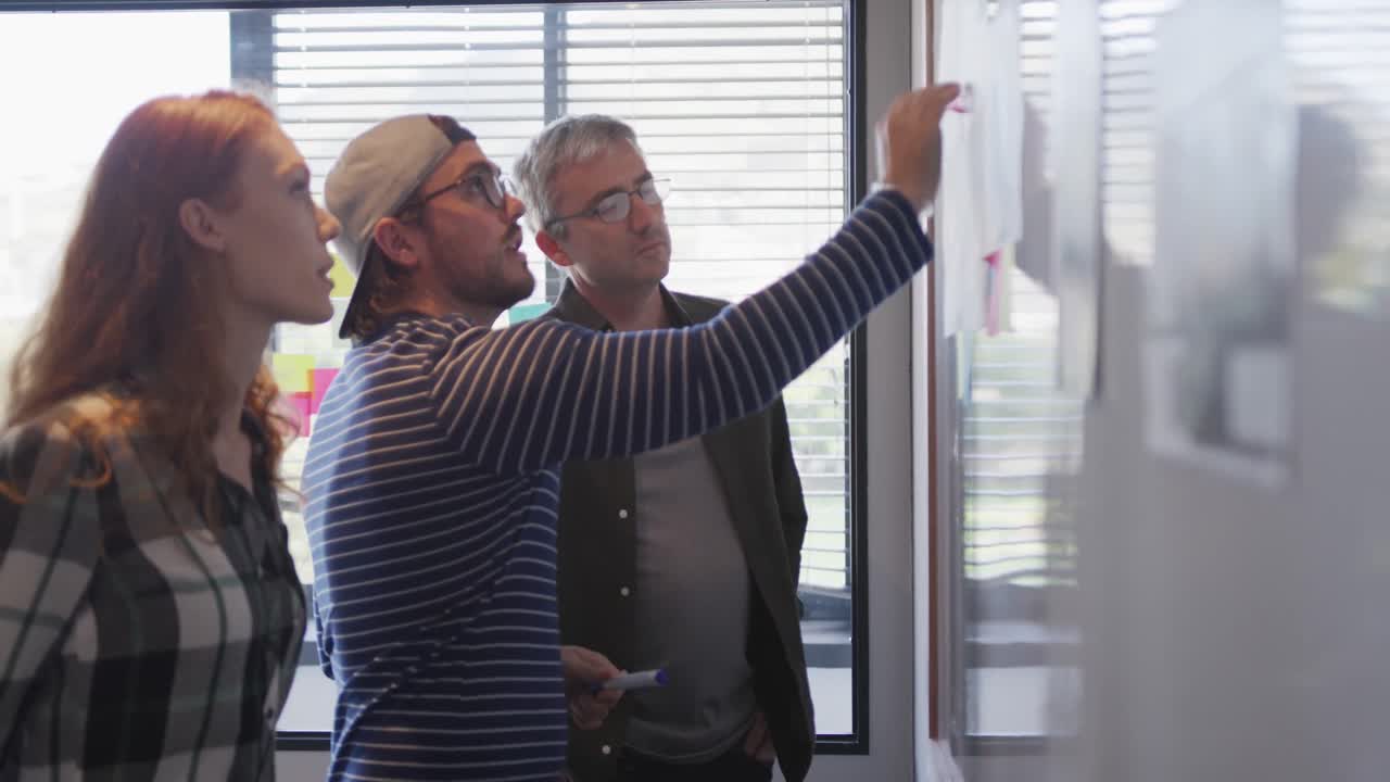 Dos hombres y una mujer trabajando en una oficina creativa