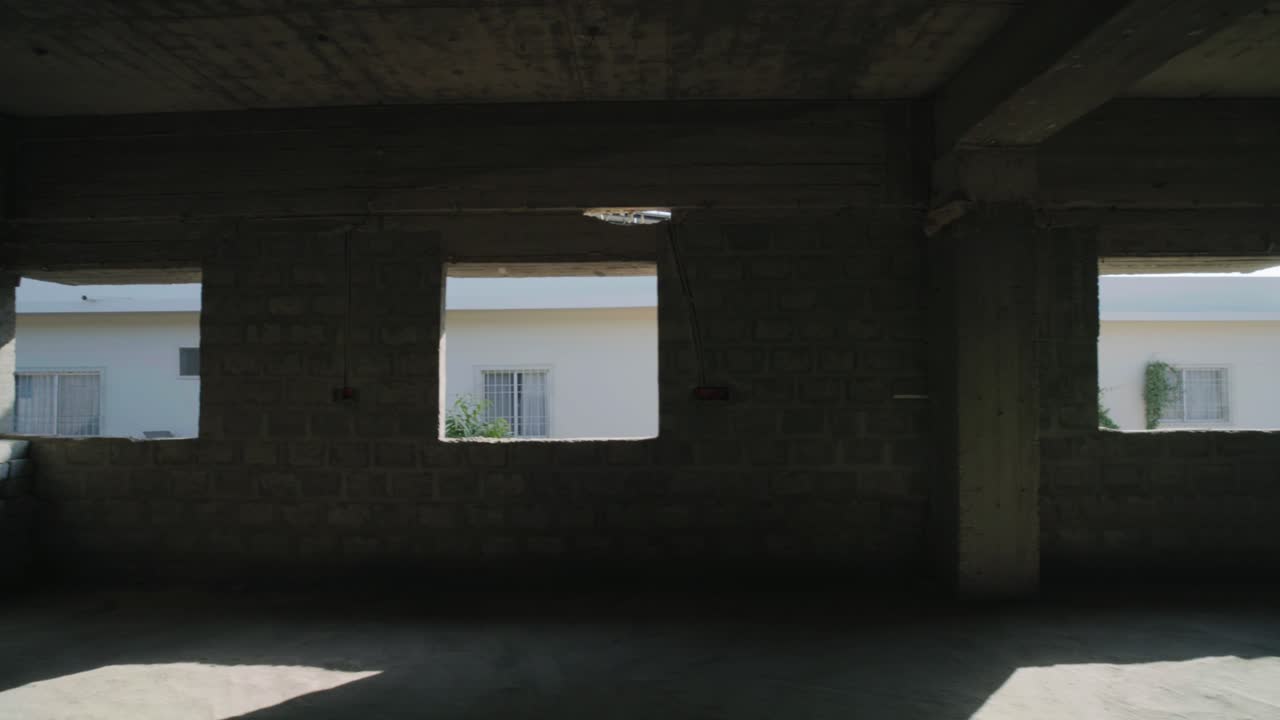 Pan shot of a hospital in construction with sunlight entering into buidling during daytime.