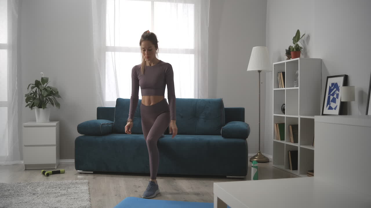 фитнес дома во время блокировки и самоизоляции женщина приседает, тренирует ноги в гостиной здоровый образ жизни и благополучие