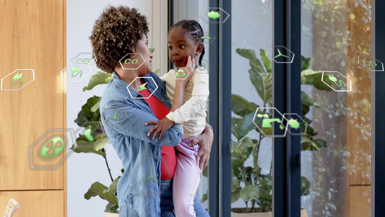 Woman carrying child at glass, child reaching and activating AR green hex icons for home energy