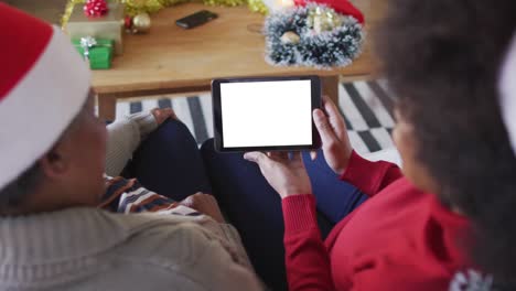 african american mother with daughter making tablet christmas video call, copy space on screen