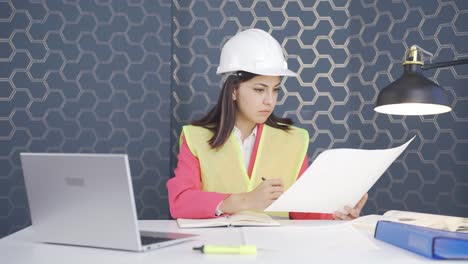 la ingeniera examina el proyecto en sus manos.