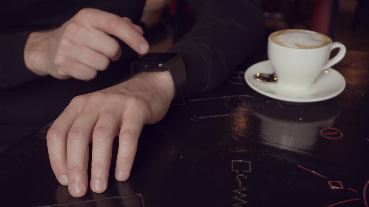 Man using smartwatch in a cafe